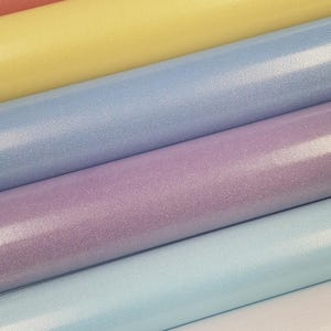 May include: Five rolls of glitter paper in various pastel colours, including pink, yellow, light blue, lavender, and white.