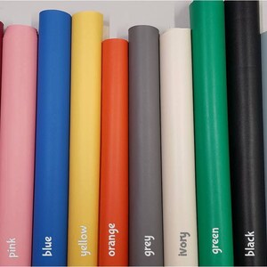 May include: A collection of 14 fabric rolls in various colours, including purple, red, dark pink, pink, blue, yellow, orange, grey, ivory, green, black, light blue, light taupe, and brown.