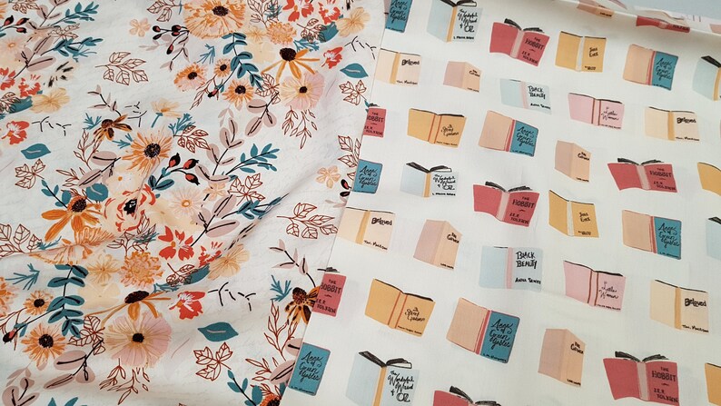 May include: Two white fabric swatches with different patterns. The left swatch has a floral pattern with orange, pink, and teal flowers. The right swatch has a repeating pattern of open books with titles like "Pride and Prejudice" and "The Hobbit".