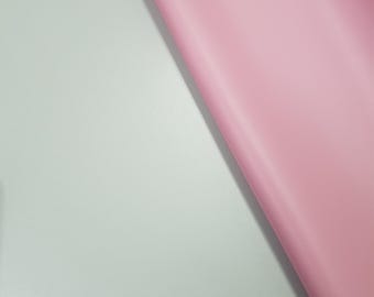 Puede incluir: Primer plano de una superficie de tela rosa claro sobre un fondo azul claro.