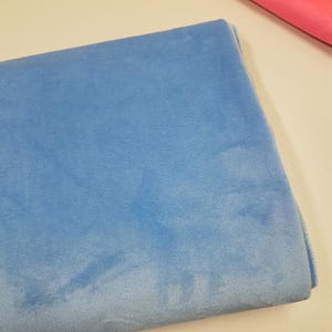 K&ouml;nnte beinhalten: Ein gefaltetes St&uuml;ck hellblauen Stoffes. Der Stoff hat eine weiche, flauschige Textur.