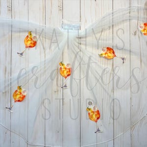 Puede incluir: Velo de novia blanco con ilustraciones de bebidas de cóctel naranja y amarillo. El velo está decorado con múltiples imágenes de la bebida.