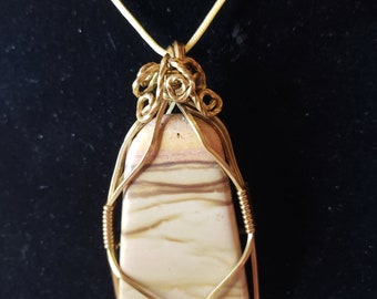 Colgante: cabujón de mármol de cebra, envoltura de alambre de oro, cadena de oro