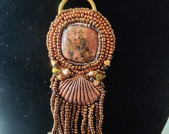 Colgante: cabujón de unikita, medallón de concha marina de latón, rocallas, borlas, cadena de cobre
