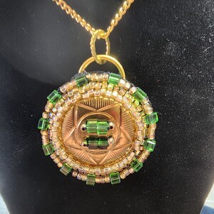 Pendant: Brass Disc, green yellow seed beads, gold chain