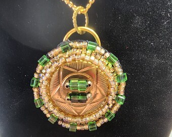 Colgante: Disco de latón, rocallas amarillas verdes, cadena de oro