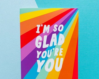 Könnte beinhalten: Eine Karte in Regenbogenfarben mit dem Text "I'm so glad you're you" in weißen Buchstaben.
