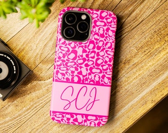 May include: Pink leopard print phone case with a pink stripe and the initials "SCJ" in white.