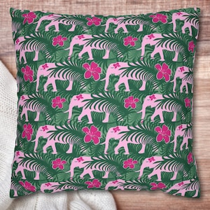 May include: A pink and green throw pillow with a repeating pattern of pink elephants and pink flowers on a green leafy background.