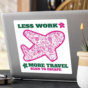 May include: A white sticker on a laptop featuring a pink airplane shape filled with a QR code pattern. The sticker has the text "LESS WORK" above the plane and "MORE TRAVEL SCAN TO ESCAPE" below, all in green and pink.