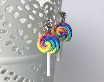 May include: Rainbow swirl lollipop earrings with silver hooks and white sticks. The lollipops are made of polymer clay.