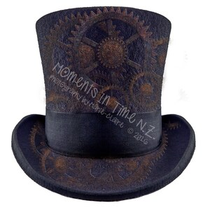May include: A black top hat with a brown and black gear design. The hat has a black band with the text "Moments in Time NZ. Photography by Marie-Claire © 2016".