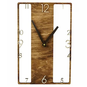 May include: A wooden wall clock with a brown wood grain finish. The clock face is surrounded by a white frame with black Roman numeral hour markers. The clock hands are black.