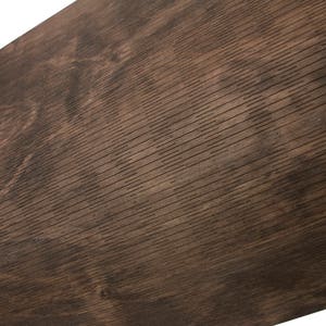 May include: Close-up of a dark brown wood grain surface with a textured pattern. The surface has a slightly rough feel and a natural, rustic look.