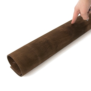 May include: A rolled up sheet of brown wood veneer with a wood grain pattern.