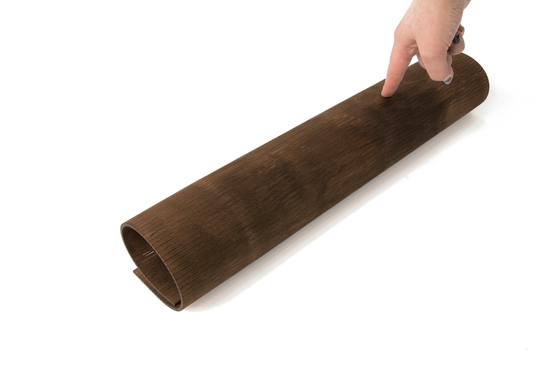 May include: A rolled up sheet of brown wood veneer with a wood grain pattern.