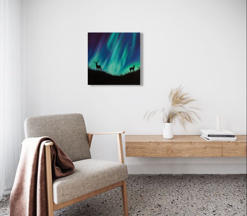 May include: A painting of a silhouette of a deer and a fawn standing in a field under a vibrant green and blue aurora borealis.