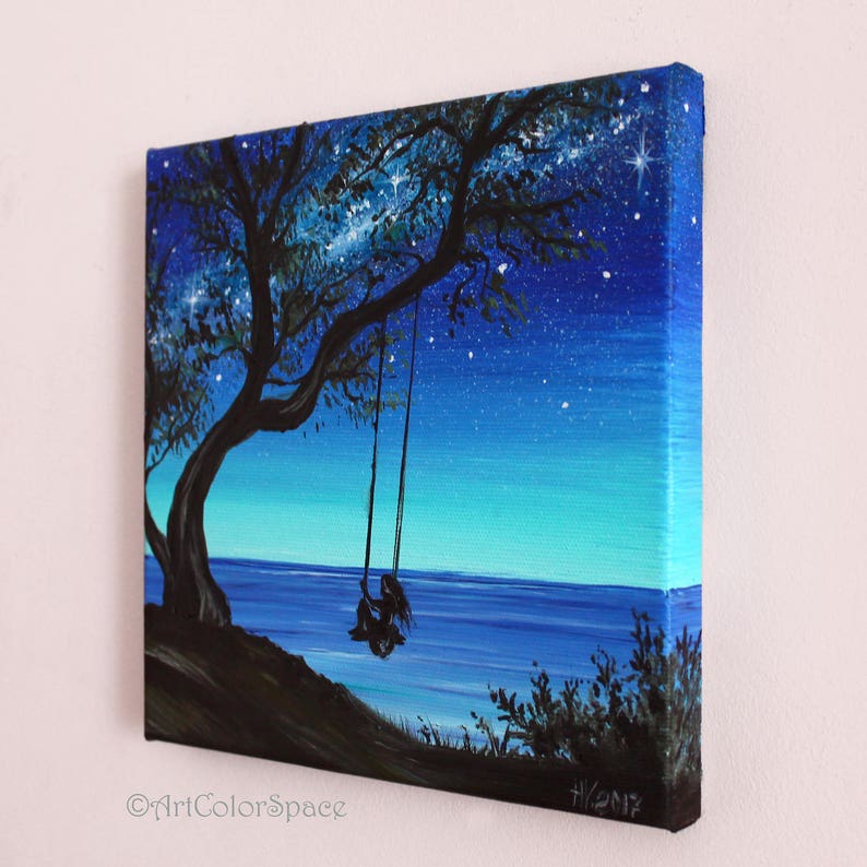 Pode incluir: Uma pintura que representa a silhueta de uma pessoa sentada em um balan&ccedil;o sob uma &aacute;rvore &agrave; noite. O c&eacute;u &eacute; azul escuro com estrelas brancas. O oceano &eacute; azul escuro no fundo. A pintura &eacute; assinada "HY2012".
