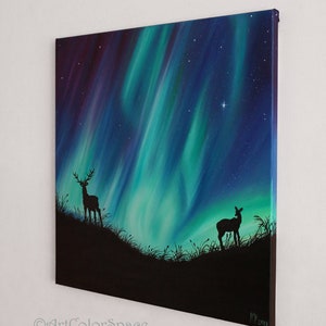 May include: A painting of a starry night sky with a vibrant green and blue aurora borealis. Two deer silhouettes stand in the foreground, one with antlers, against a dark landscape.