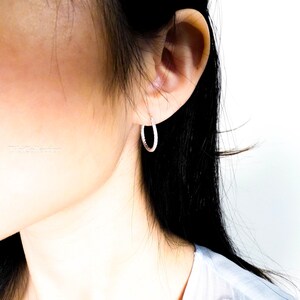 Close up of twisted textured sterling silver hoop earrings