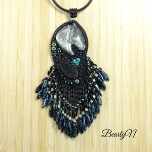 May include: Black beaded necklace with a silver horse head pendant and turquoise accents. The necklace features a long, fringed design.