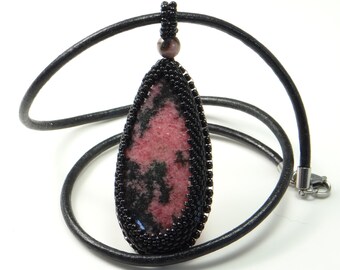 Collier pendentif avec cabochon de rhodonite en forme de goutte, serti et brodé de perles noires