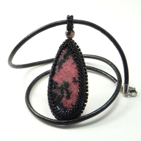 Collier pendentif avec cabochon de rhodonite en forme de goutte, serti et brodé de perles noires