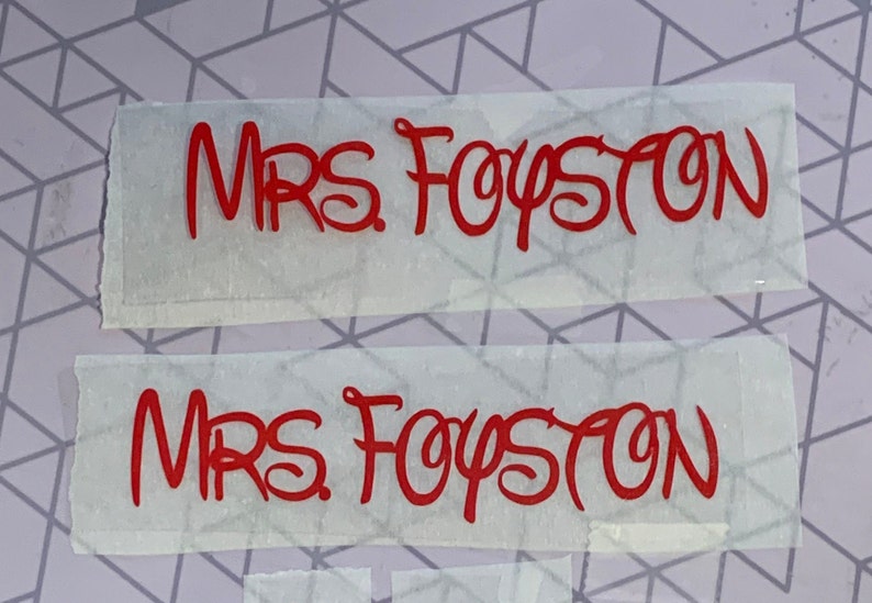Puede incluir: Dos hojas blancas de papel con el texto "MRS FOYSTON" escrito en letras cursivas rojas.