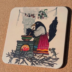 May include: Square coaster with a folk art illustration of a bird cooking. The bird, wearing an apron, stirs a pot over a brick oven. A mouse holds cheese. The image has a whimsical style with a rustic feel.