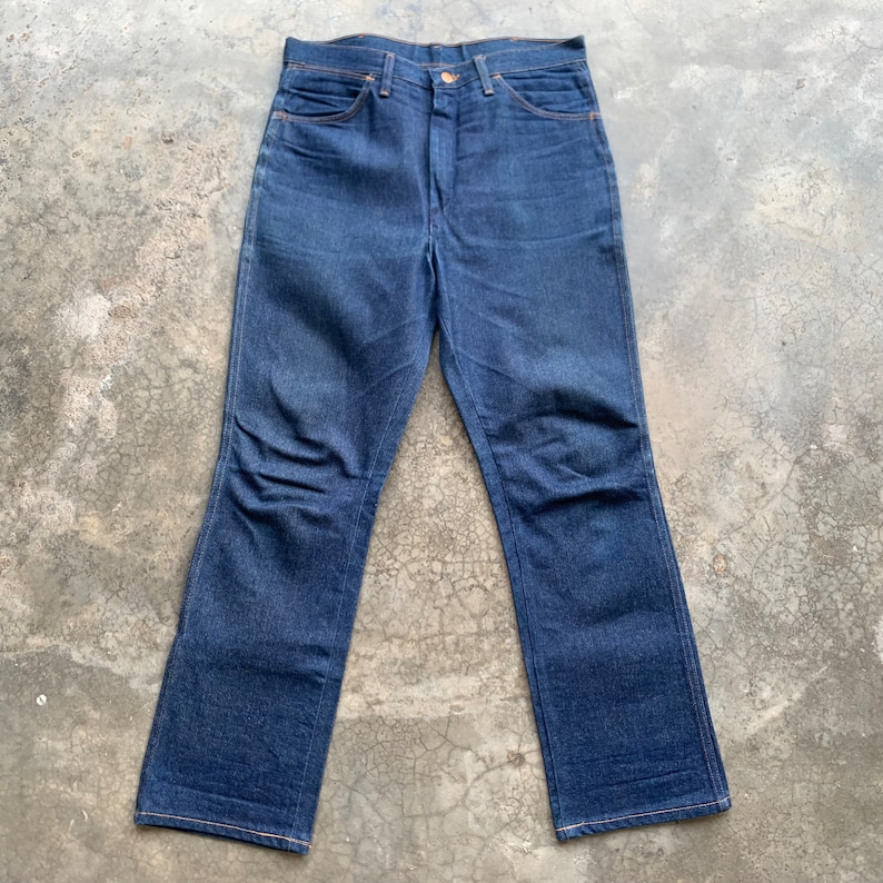 K&ouml;nnte beinhalten: Dunkelblaue Jeans aus Denim mit klassischem F&uuml;nf-Taschen-Design. Die Jeans haben einen geraden Beinverlauf und einen Knopf- und Rei&szlig;verschluss. Die N&auml;hte sind in einer kontrastierenden Beiget&ouml;nung gehalten.