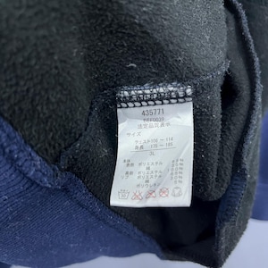 Puede incluir: Primer plano de una prenda negra y azul marino con una etiqueta. La etiqueta muestra el n&uacute;mero 435771, la talla 3L y texto japon&eacute;s con medidas de pecho y altura. La tela es de poli&eacute;ster y poliuretano.