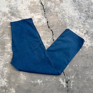 Può includere: Pantaloni da lavoro blu con gamba dritta e una singola tasca laterale. I pantaloni sono realizzati in un materiale robusto. Questi pantaloni sono adatti per il lavoro o per il tempo libero. Misurano circa 100 cm di lunghezza.