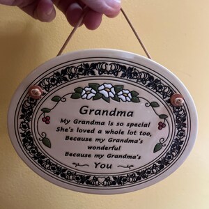 May include: A ceramic oval plaque with a floral design and the text "Grandma". The plaque reads "My Grandma is so special She's loved a whole lot too, Because my Grandma's wonderful Because my Grandma's You".