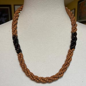 Licht- en donkerbruine houten gedraaide ketting met gouden accentkralen