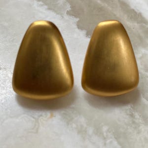 May include: A pair of gold-toned triangle shaped earrings.