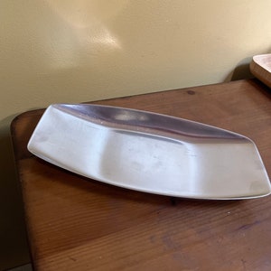 Peut inclure: Un plateau de service en argent avec trois sections. Le plateau est de forme ovale et présente un design légèrement incurvé.