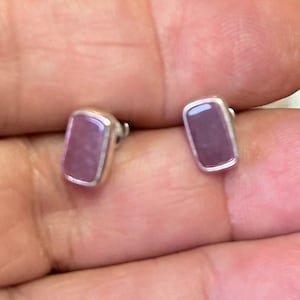 May include: A pair of silver stud earrings with rectangular pink stones.