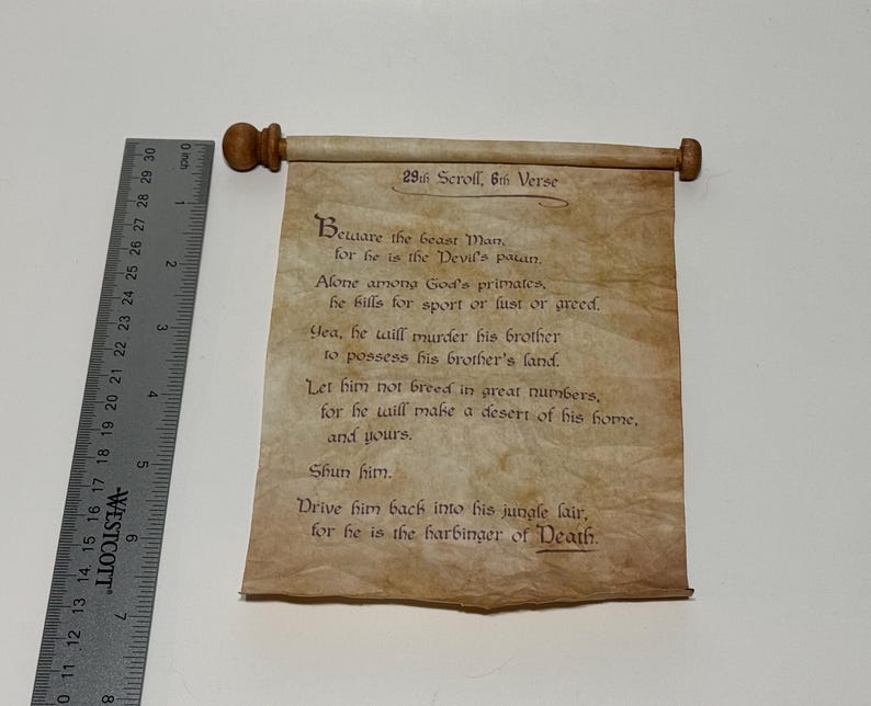 Puede incluir: Un rollo de pergamino con un rollo de madera en cada extremo. El rollo est&aacute; enrollado y atado con una cuerda. El texto en el rollo dice: "29th Scroll, 6th Verse Beware the beast Man for he is the Devil's spawn. Alone among God's primates, he kills for sport or lust or greed. Yea, he will murder his brother to possess his brother's land. Let him not breed in great numbers, for he will make a desert of his home, and yours. Shun him. Drive him back into his jungle lair, for he is the harbinger of Death."