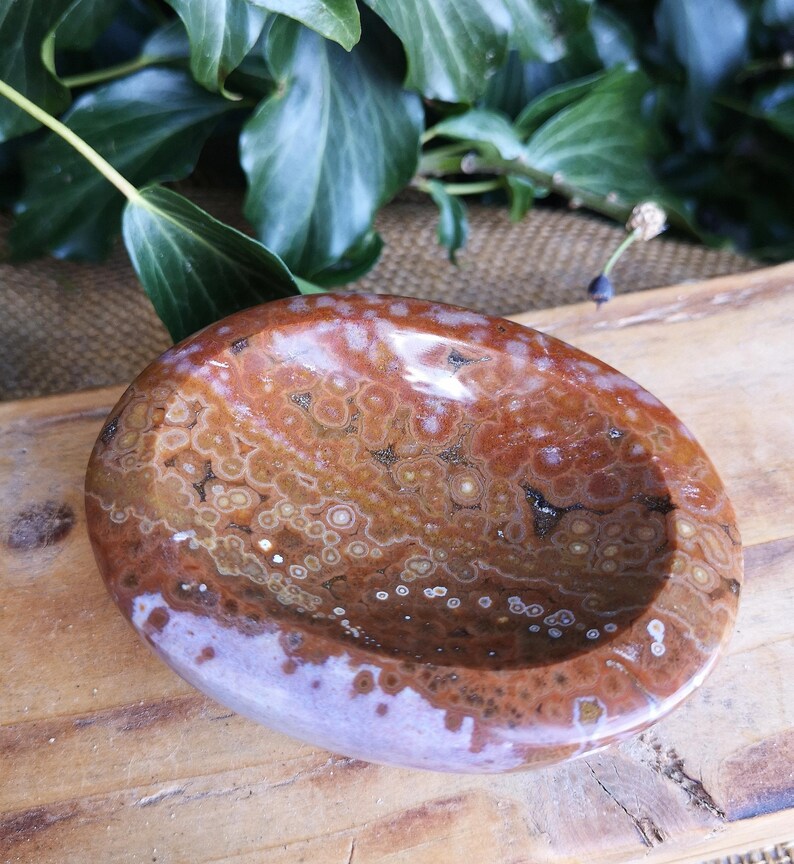 May include: A brown and white agate bowl with a swirling pattern. The bowl is oval shaped and has a smooth, polished finish.