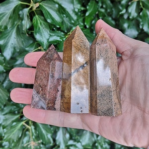 Puede incluir: Tres varitas de cristal pulidas, puntiagudas, con rayas marrones y blancas. Las varitas est&aacute;n dispuestas en fila, con la varita m&aacute;s grande en el centro.