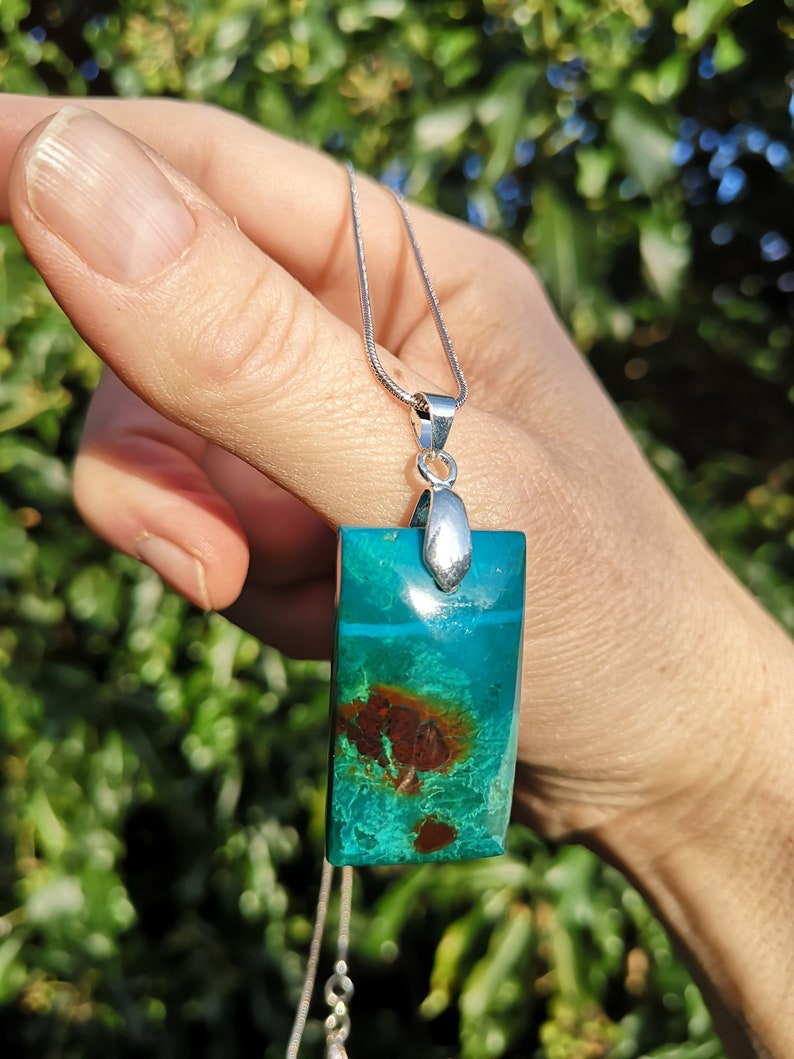 Pu&ograve; includere: Collana con pendente rettangolare in pietra preziosa turchese e marrone. La catena &egrave; d'argento. I colori e i motivi del pendente creano un contrasto sorprendente, rendendolo un gioiello unico.
