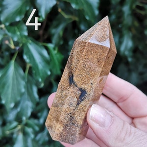 Puede incluir: Una punta de cristal marr&oacute;n y negro con un patr&oacute;n &uacute;nico de m&aacute;rmol. La punta est&aacute; pulida y tiene un acabado liso y brillante.