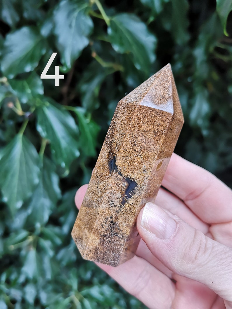 Puede incluir: Una punta de cristal marr&oacute;n y negro con un patr&oacute;n &uacute;nico de m&aacute;rmol. La punta est&aacute; pulida y tiene un acabado liso y brillante.