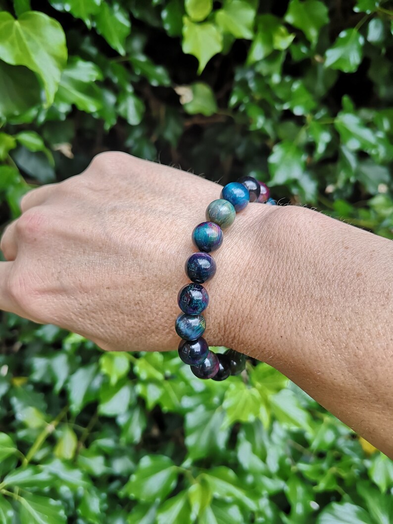 May include: A beaded bracelet with dark blue, green, and red beads. The bracelet is made of natural stone and has a polished finish.