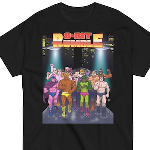 May include: Black t-shirt with a graphic of wrestlers in a retro 8-bit style. The text "8-Bit Rumble" is in a bright yellow and orange font.