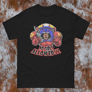 May include: Black t-shirt with a cartoon illustration of a muscular figure in red and yellow armour, holding a weapon. The text "NO GIRLS ALLOWED!!!" is in red and white.