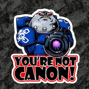 Pode incluir: Um adesivo com um personagem de desenho animado em armadura azul com uma arma grande. O personagem tem uma cabeça cinza e olhos vermelhos, com o texto "YOU'RE NOT CANON!" em negrito, vermelho e branco.