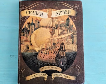 May include: A brown book with a gold illustration of a ship sailing between two cities. The title of the book is "СКАЗКИ ДРУЗЕЙ" and the publisher is "...ДЕТСКАЯ ЛИТЕРАТУРА..."