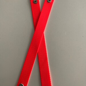May include: Two bright orange straps with metal eyelets at each end.
