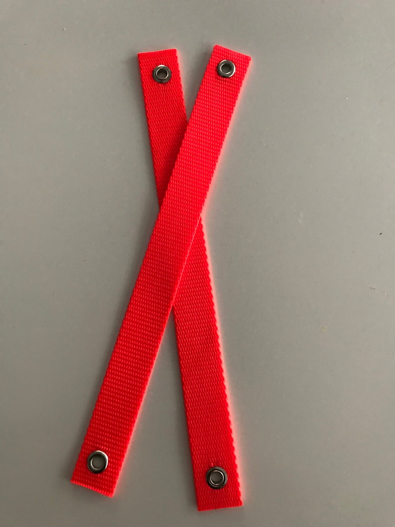 May include: Two bright orange straps with metal eyelets at each end.